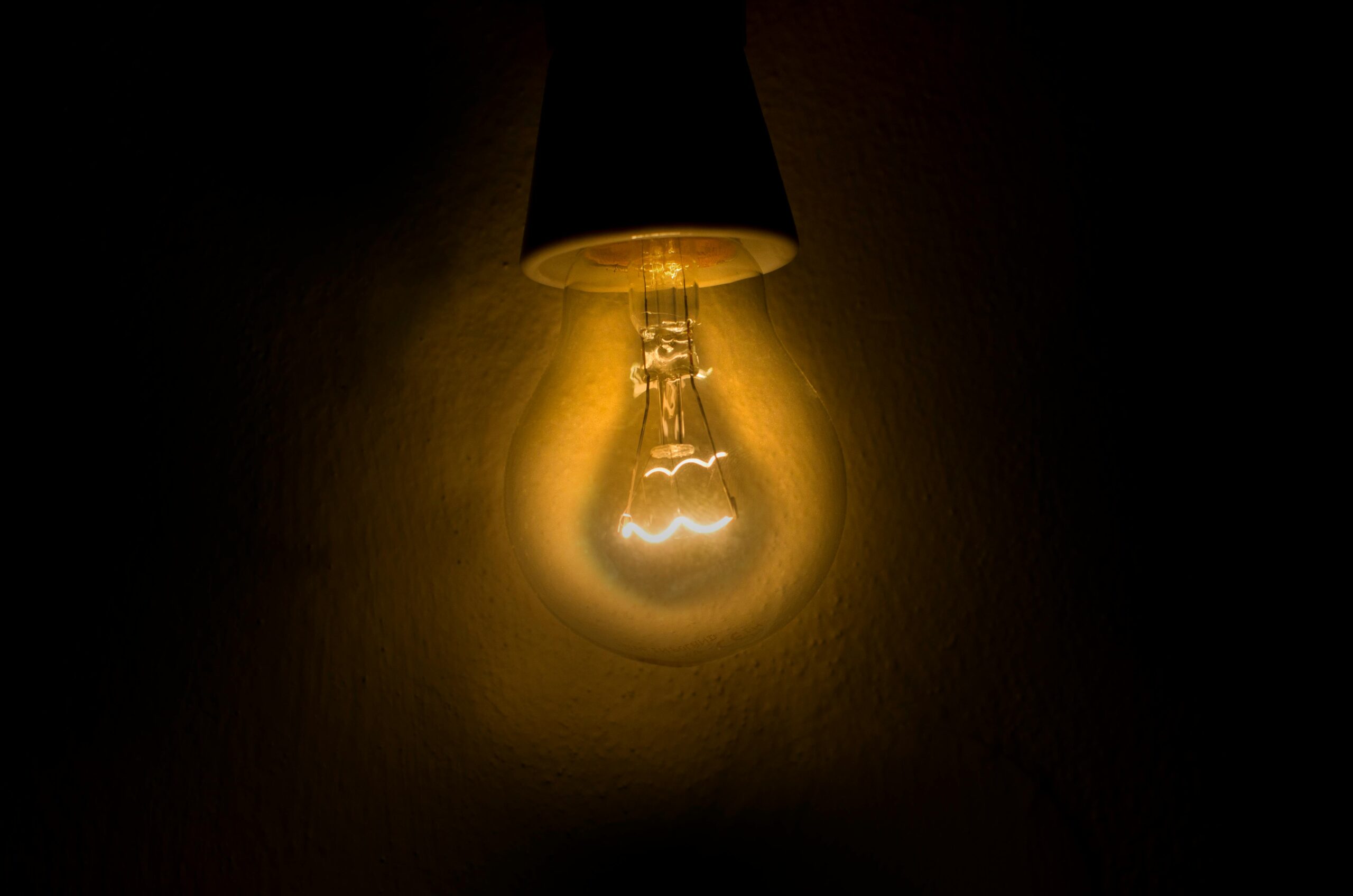 Warm glow of an illuminated light bulb against a dark backdrop, symbolizing ideas and innovation.